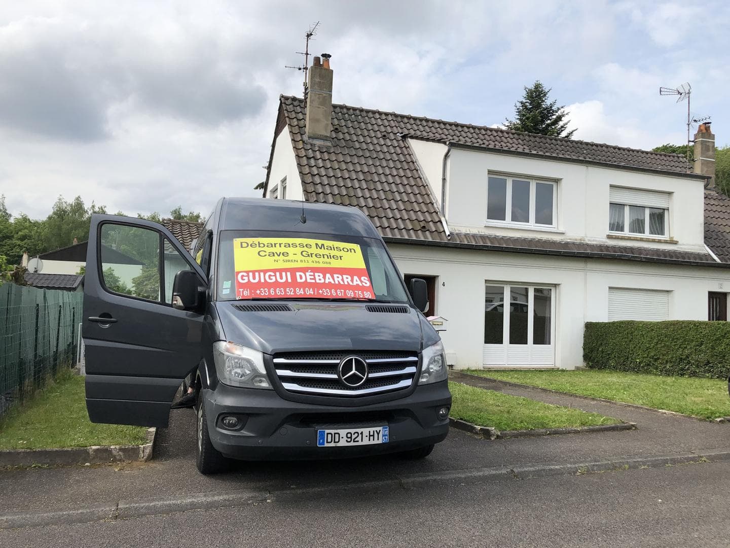 Camion GUIGUI DEBARRAS stationné devant une maison pendant un débarras